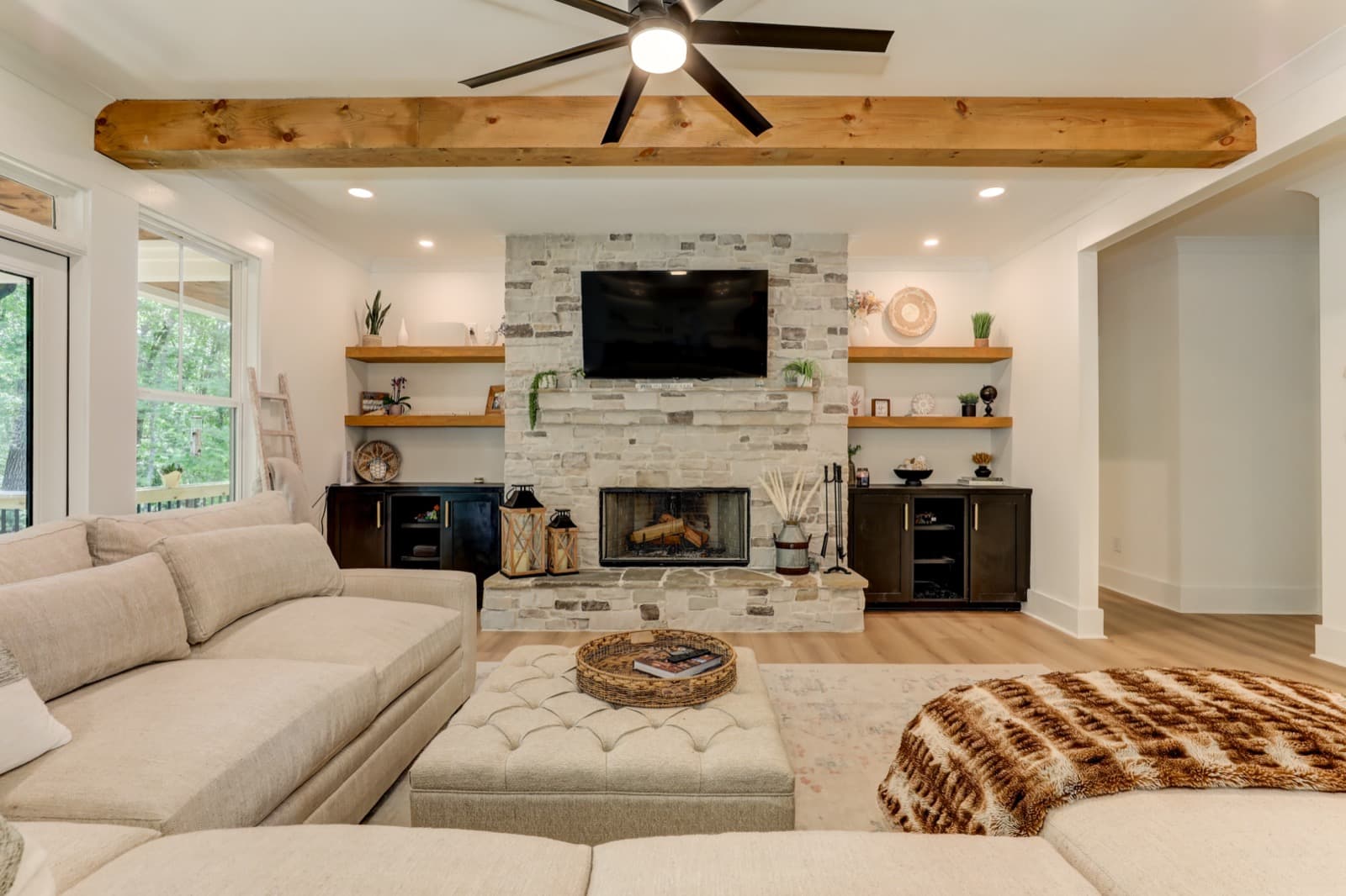 A warm great room with a stone fireplace, built by JL Development